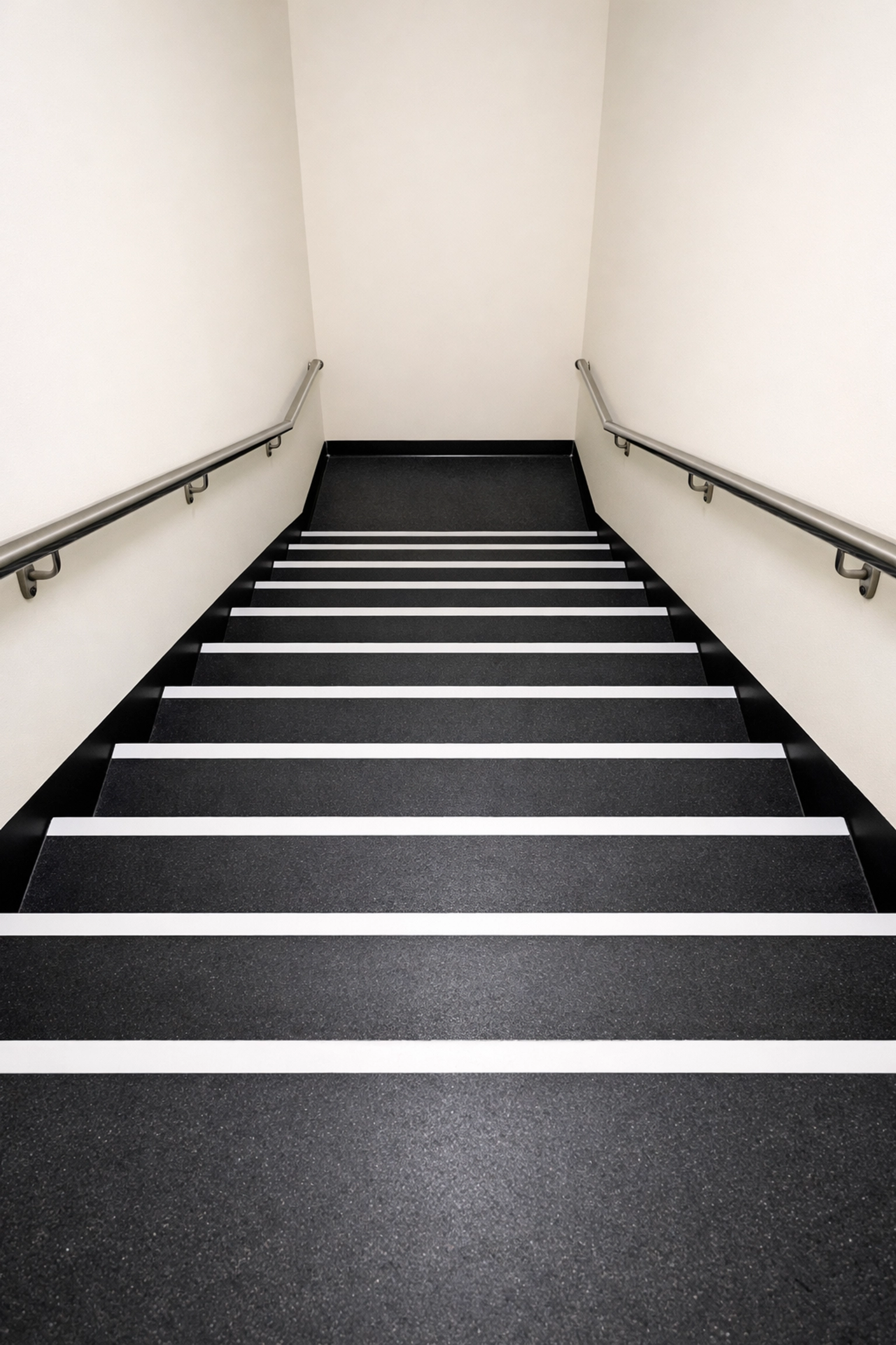High-contrast stairs with dark treads and white edges to improve depth perception and step visibility.