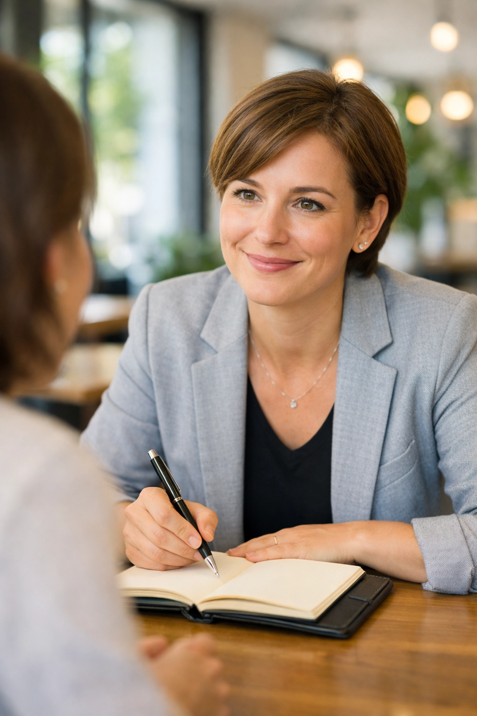 A professional researcher taking notes during a customer interview to gather deep market insights.