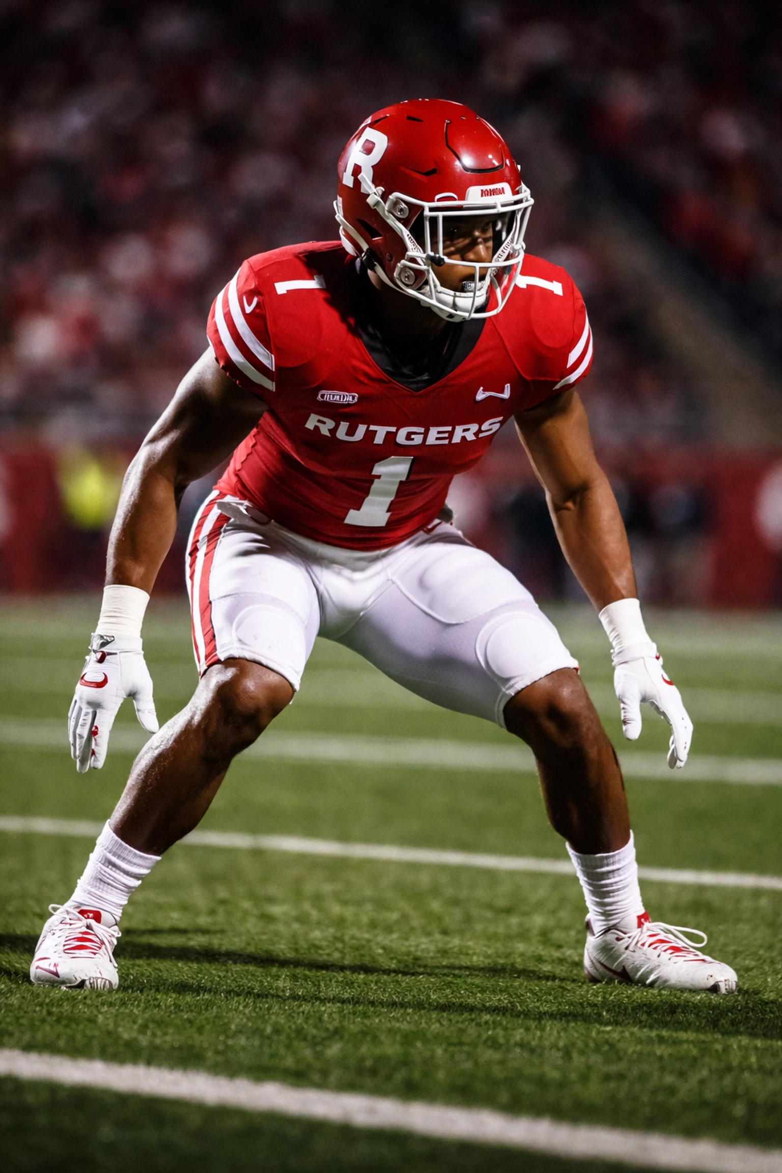 Rutgers football cornerback in defensive stance during night game highlighting athleticism and focus