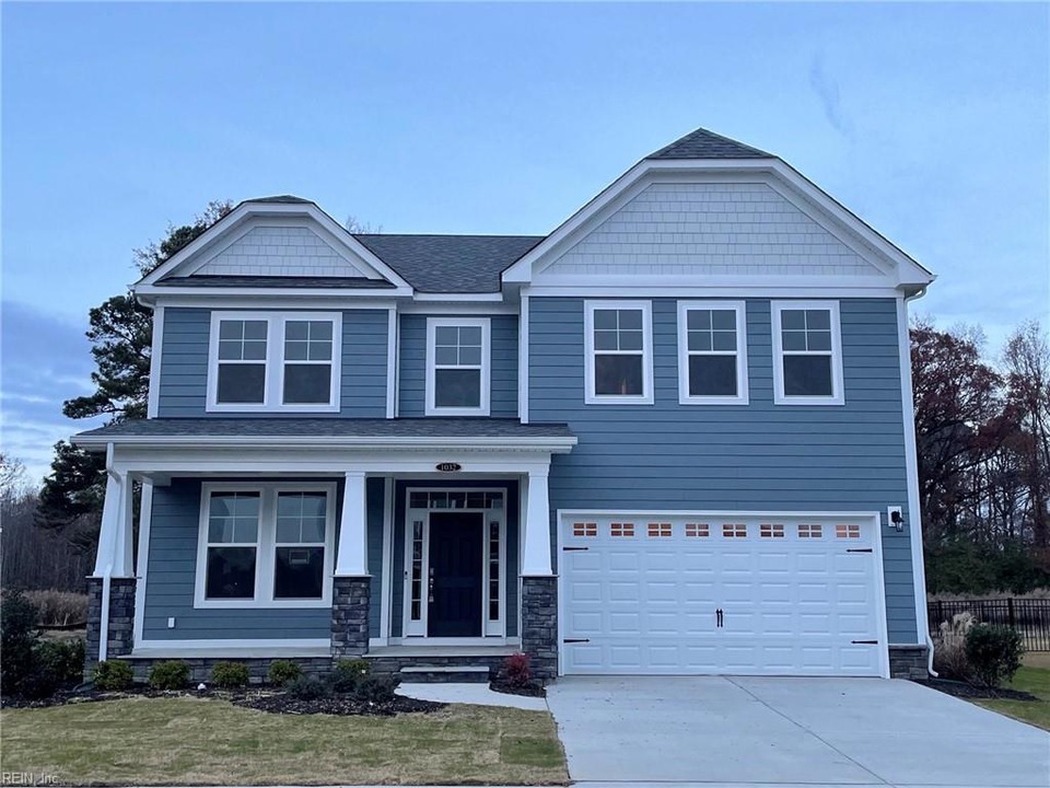 Modern two-story single-family home Modern two-story single-family home with blue siding, stone accents, covered front porch, attached two-car garage, and professionally landscaped yard, ideal for Hampton Roads buyers seeking spacious and stylish suburban living.