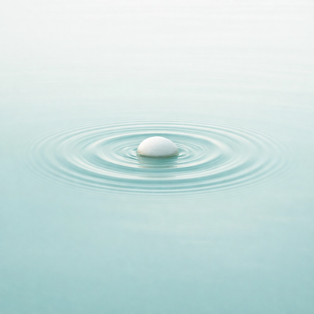Water ripples from a single stone, representing naming a loss and the start of grief recovery.