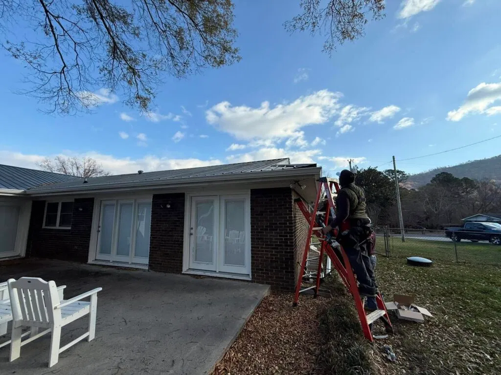 Technician on a ladder performing a professional roof and gutter inspection