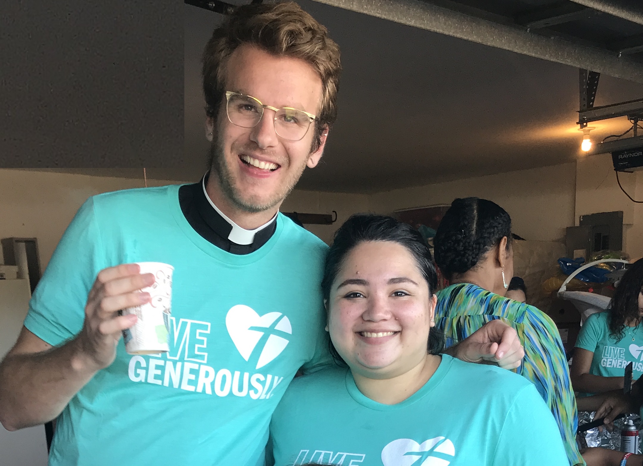 Two individuals in “Live Generously” shirts