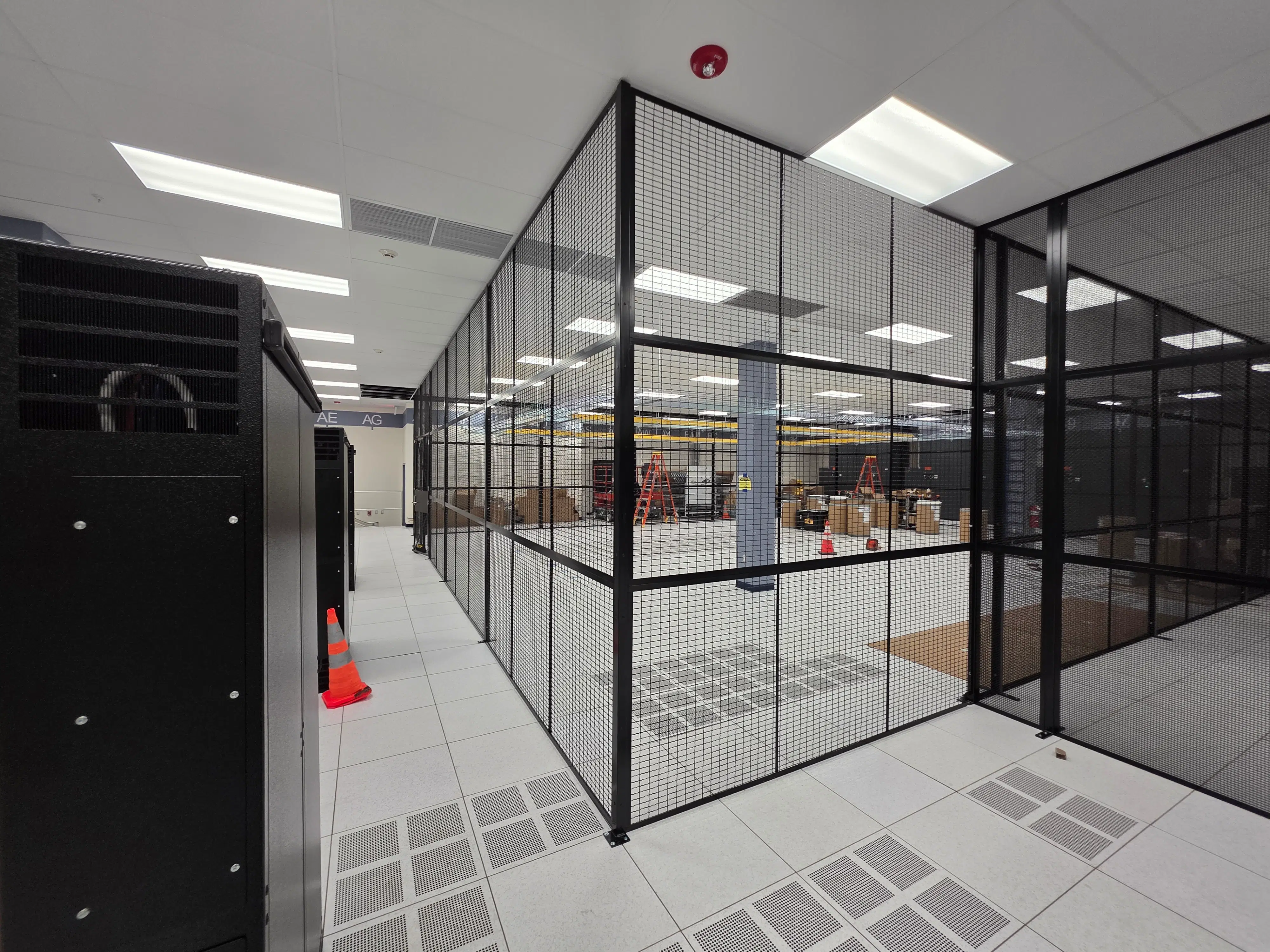 Large format industrial security cage protecting high-value inventory rows in a modern distribution center.