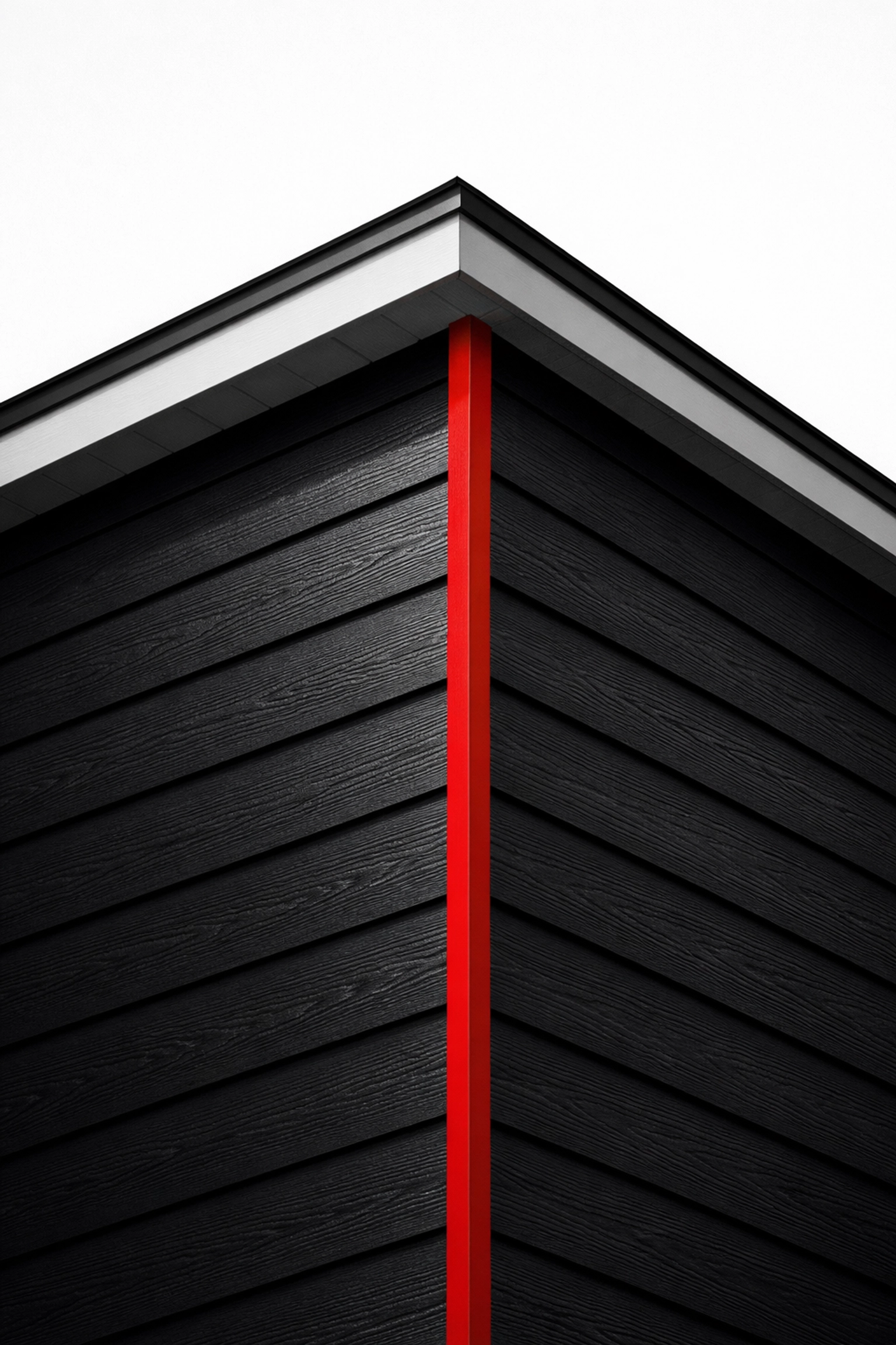 Charcoal black fiber cement lap siding with wood-grain texture and modern red trim accent.