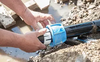 Technician installing or repairing a water main pipe with a compression fitting