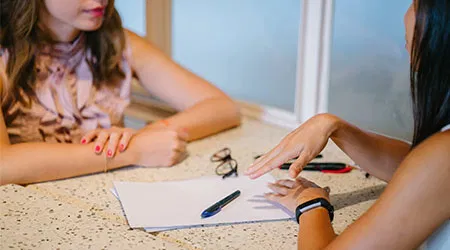 A professional consultation between a migration agent and a client, focusing on the details of the citizenship application.