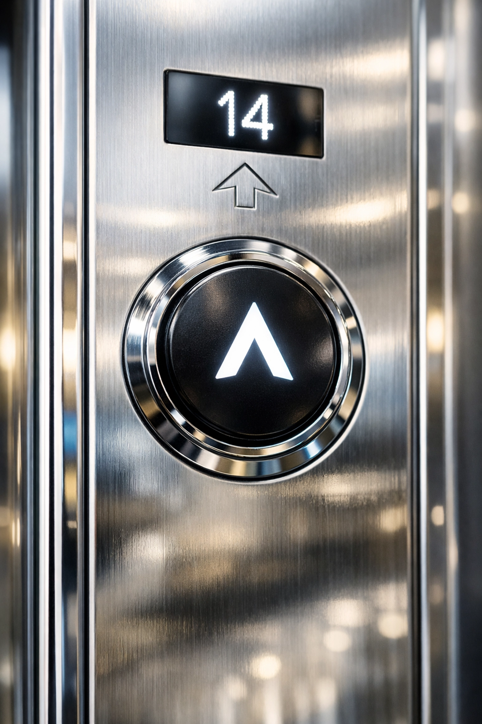 Polished stainless steel elevator panel in a clean office, highlighting high-touch surface hygiene.