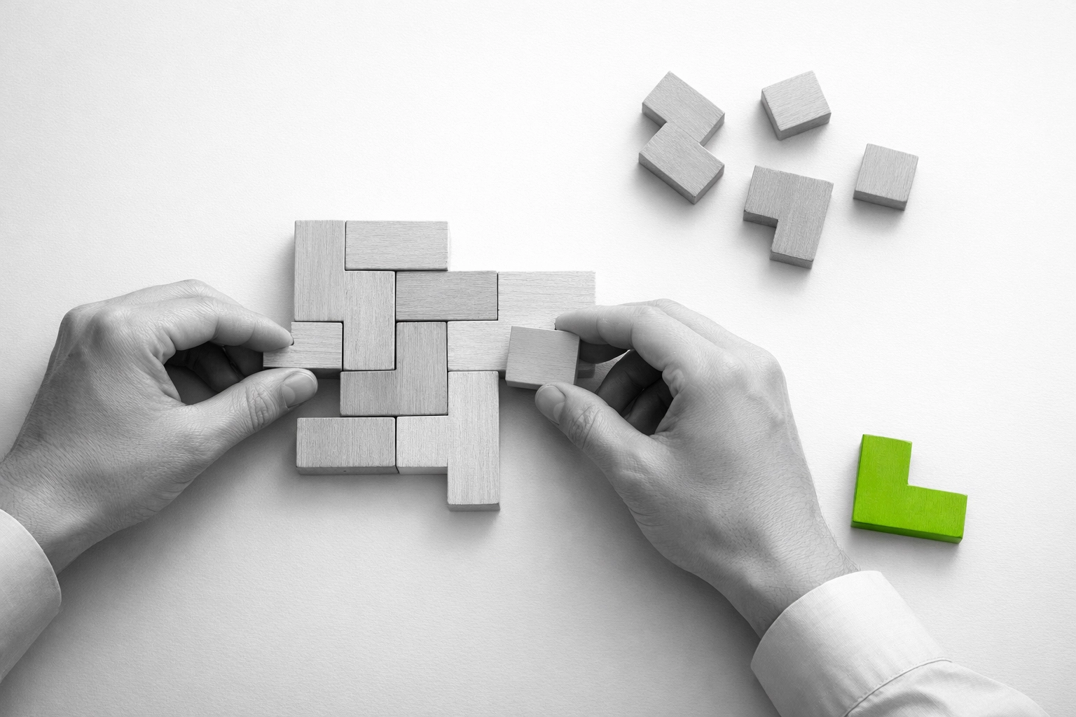 Hands arranging puzzle pieces representing strategic decision-making and organizational efficiency