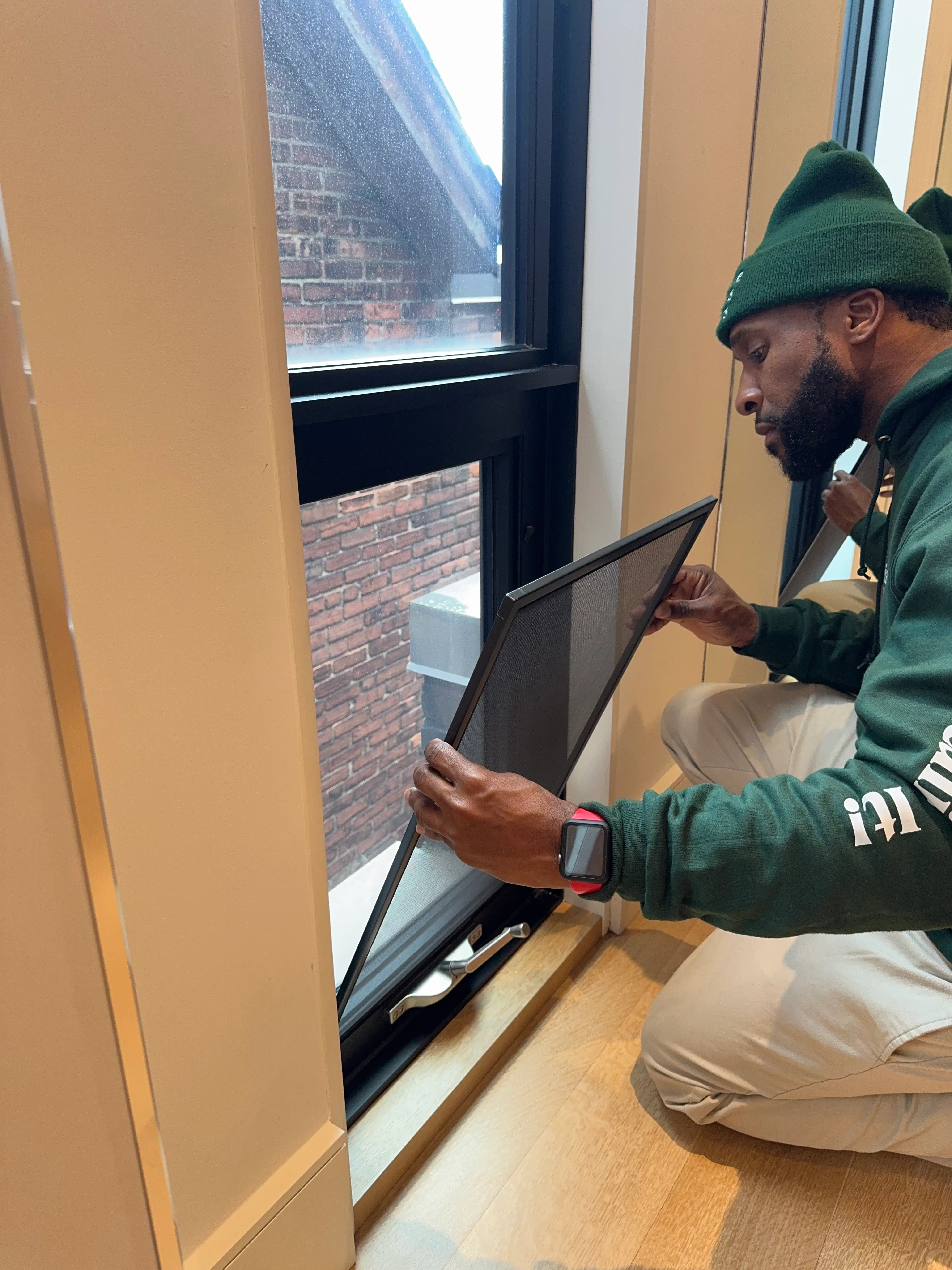 Professional installation of a new black-framed window screen