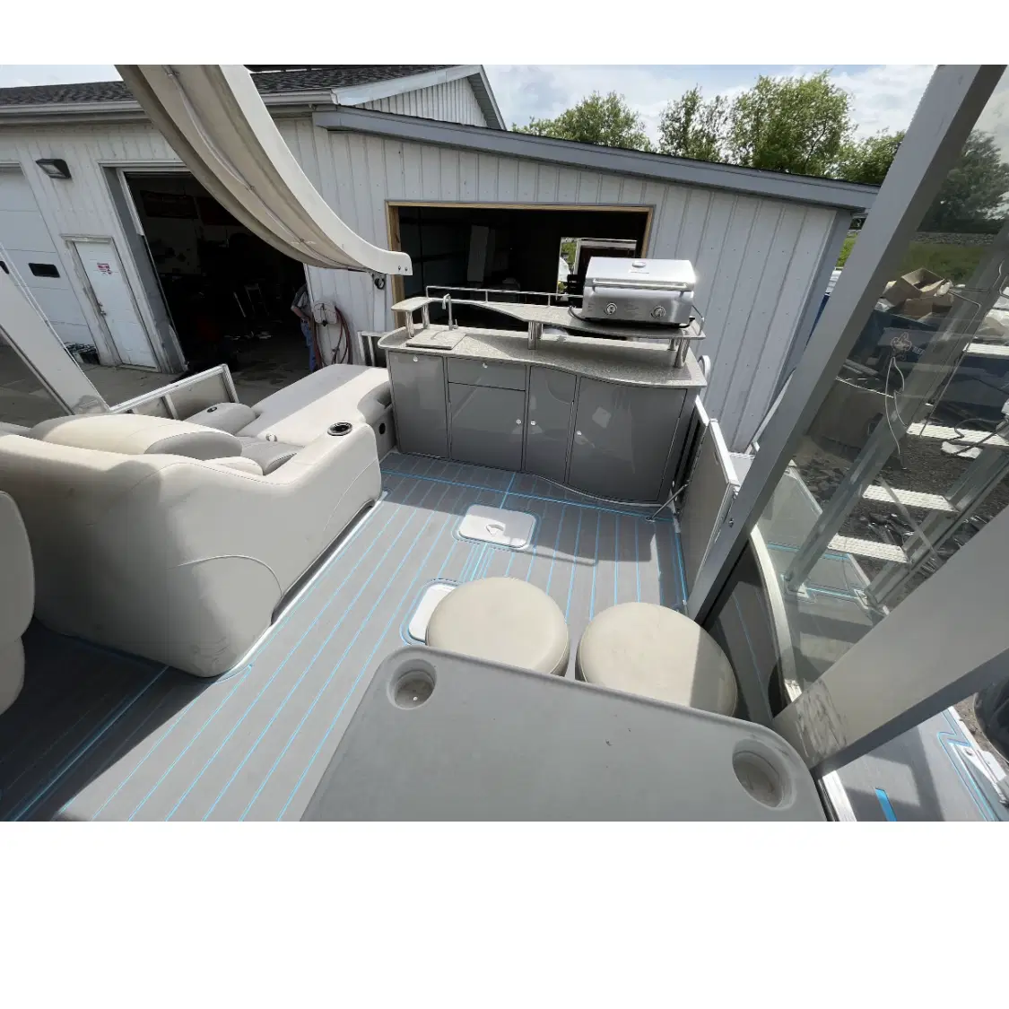 A luxury kitchenette area featuring a high-end grill, sink, and integrated bar stools for social cooking