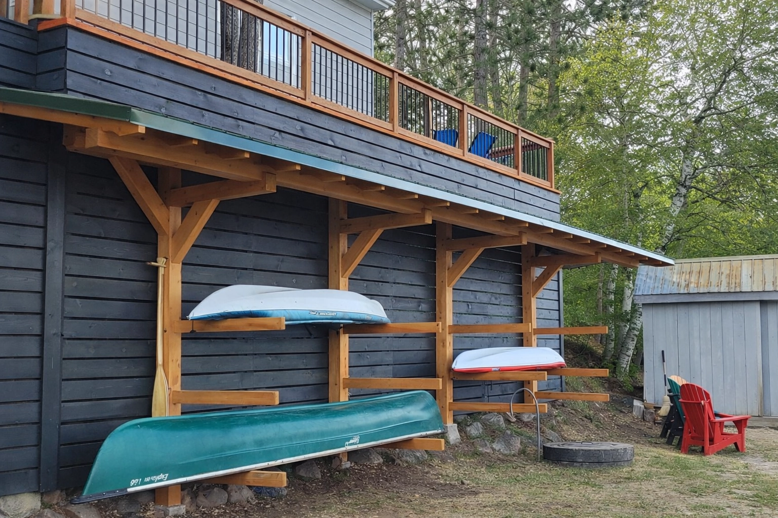 Custom timber frame boat rack structure integrated under a lakeside deck.