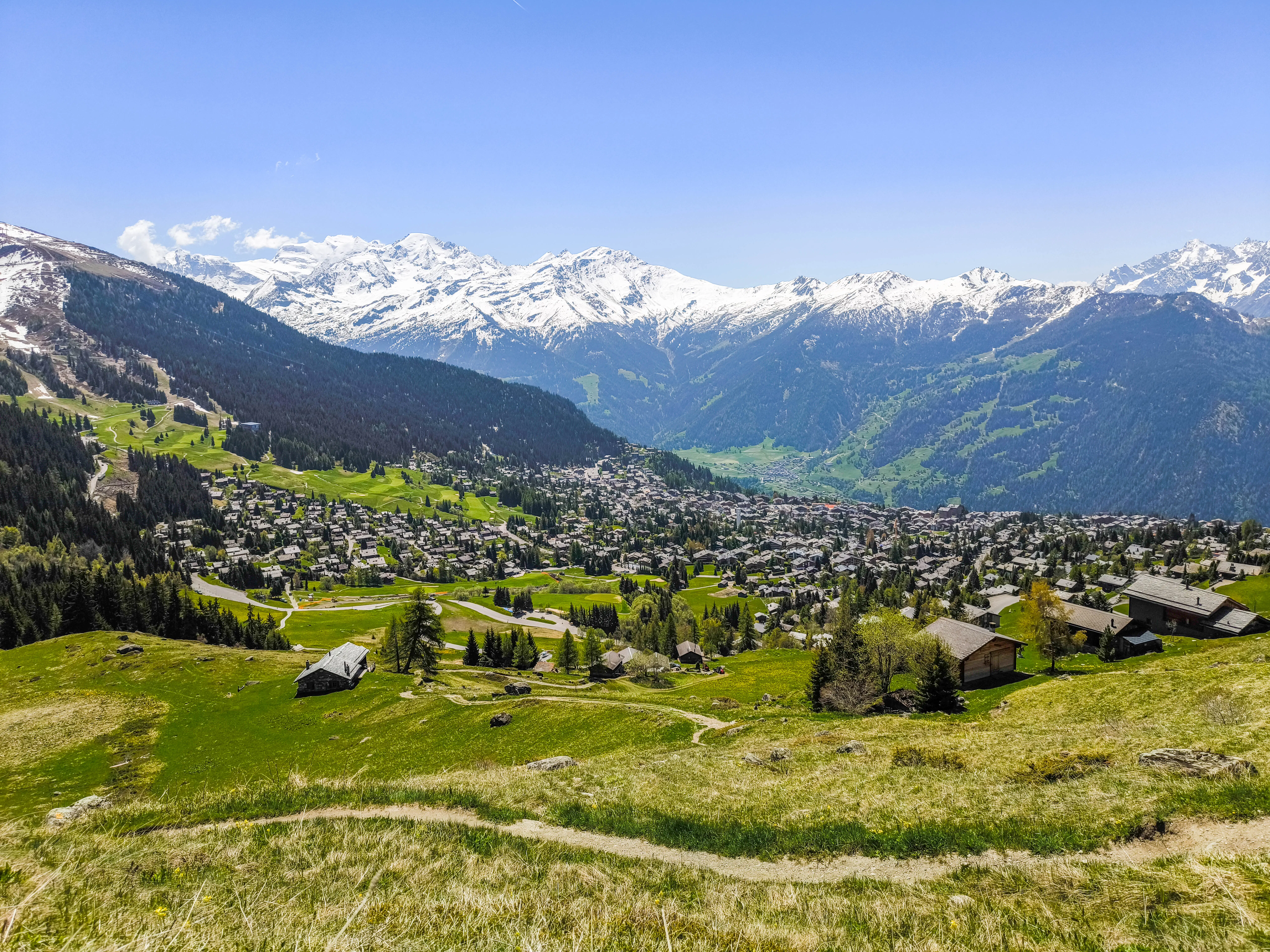 Panoramic view of Verbier village with luxury chalets nestled among green alpine meadows