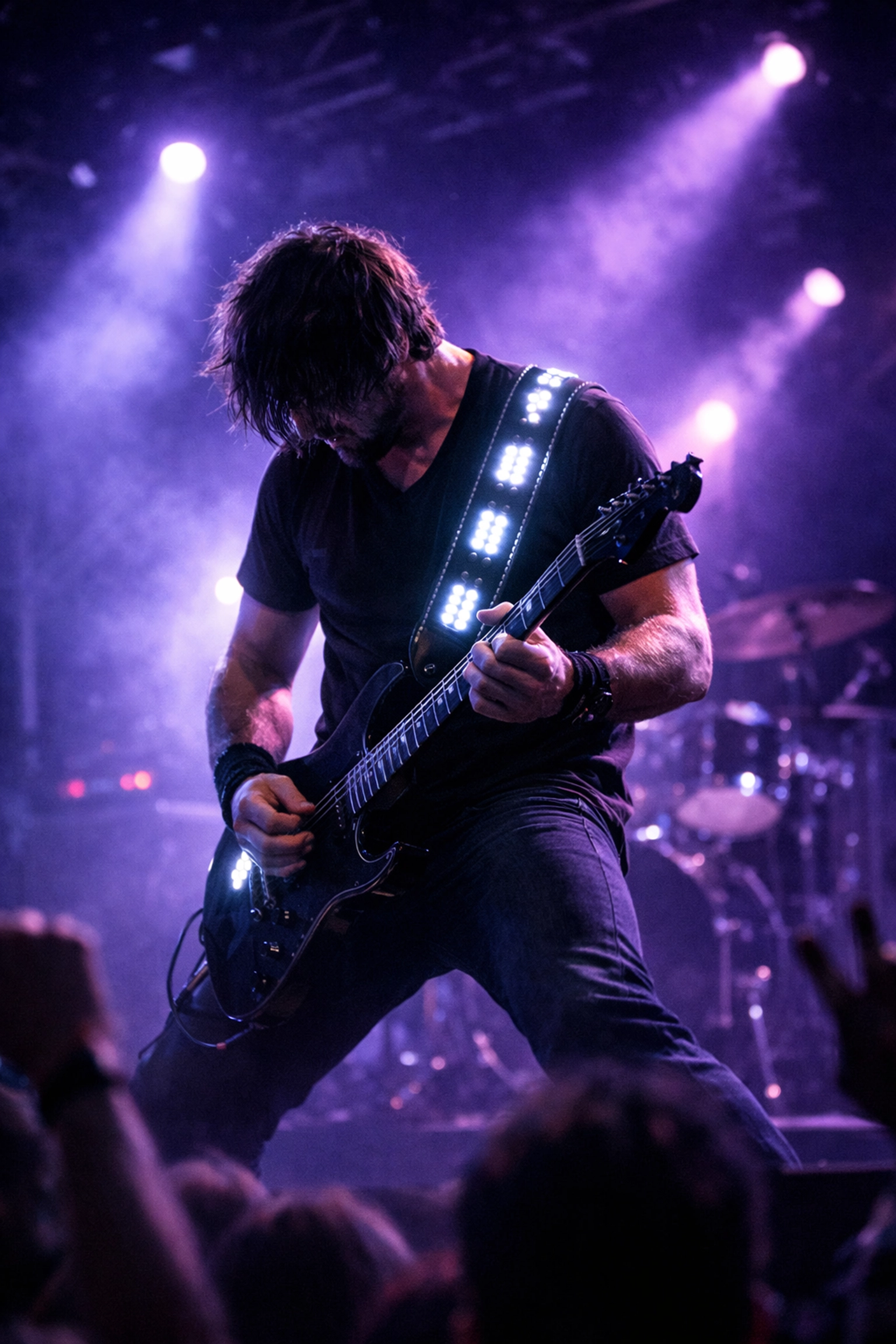 Sound-activated LED guitar strap illuminating during live stage performance
