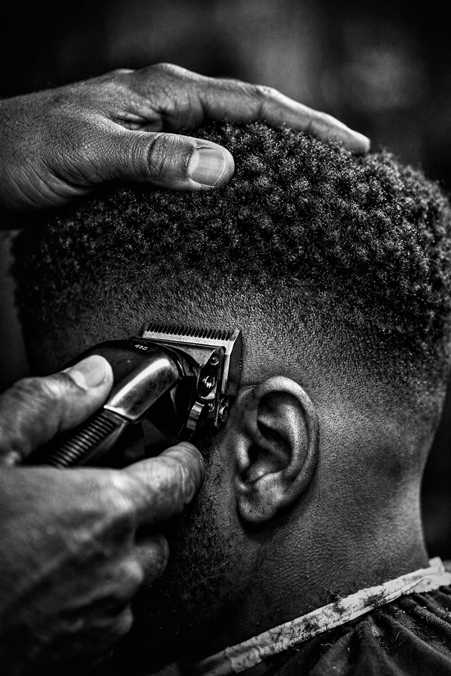 Professional barber performing precision fade on textured hair demonstrating comprehensive texture training