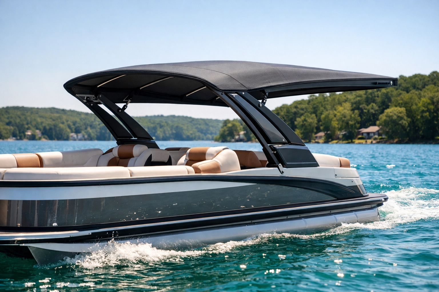 Modern charcoal power bimini top on a luxury pontoon boat providing shade on a sunny lake.