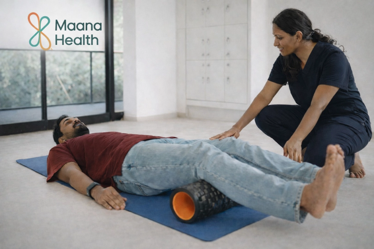 A patient using a foam roller for myofascial release under supervision at Maana Health