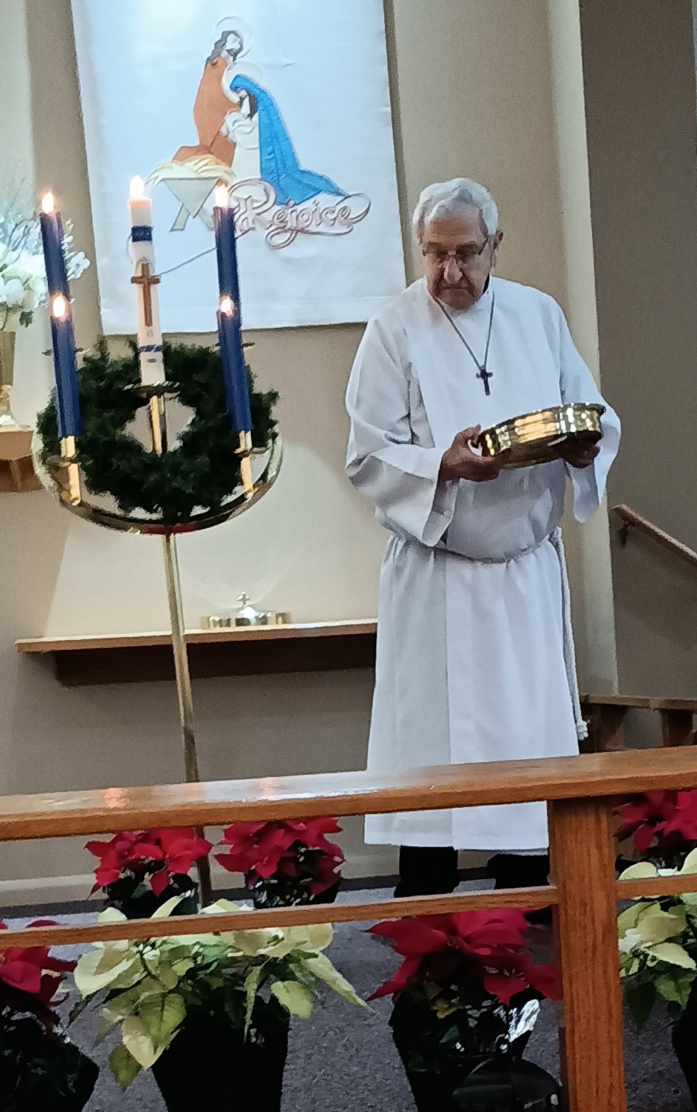 A minister in a white robe at the front of a church