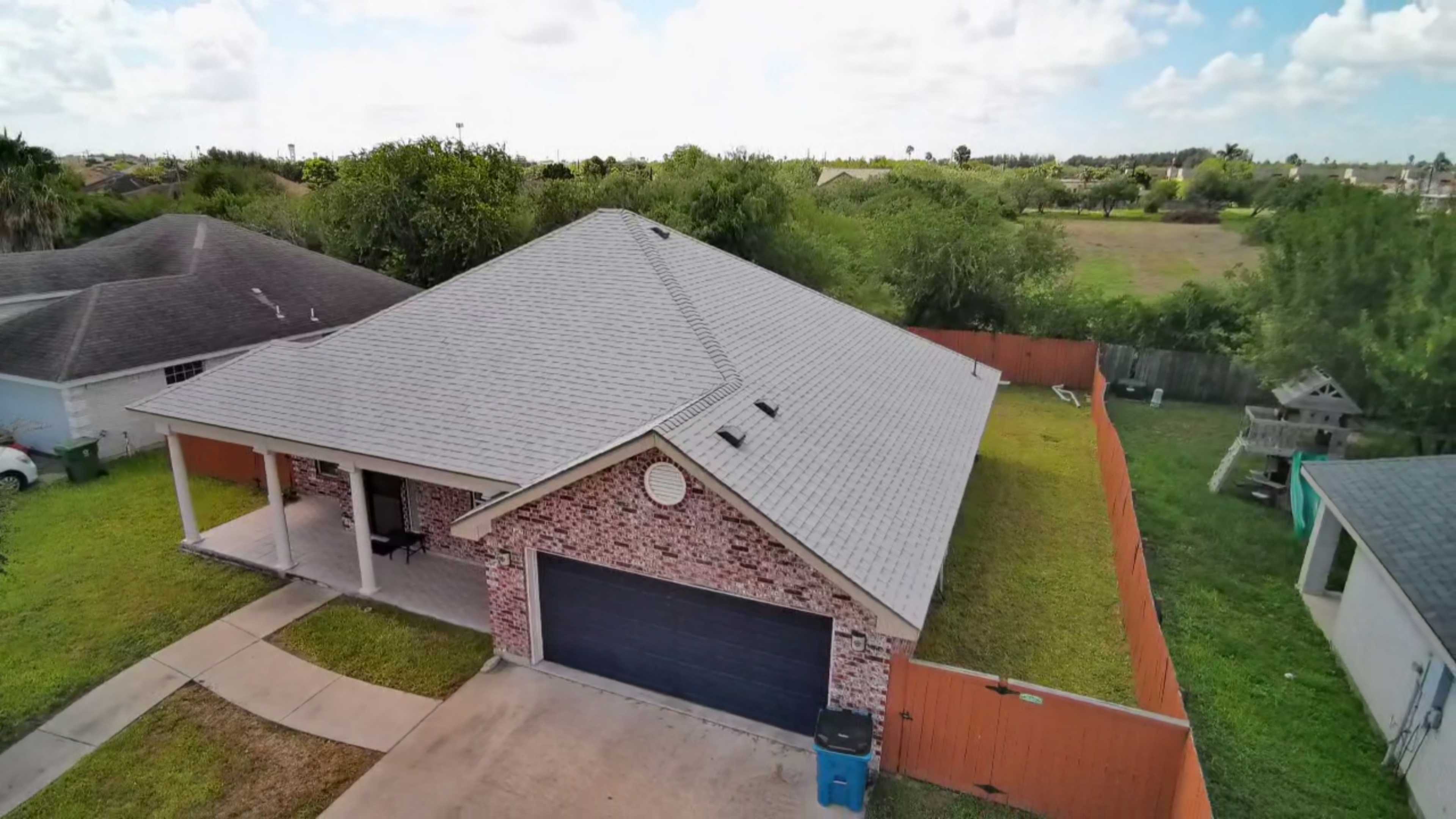 Newly installed asphalt shingle roof on brick home