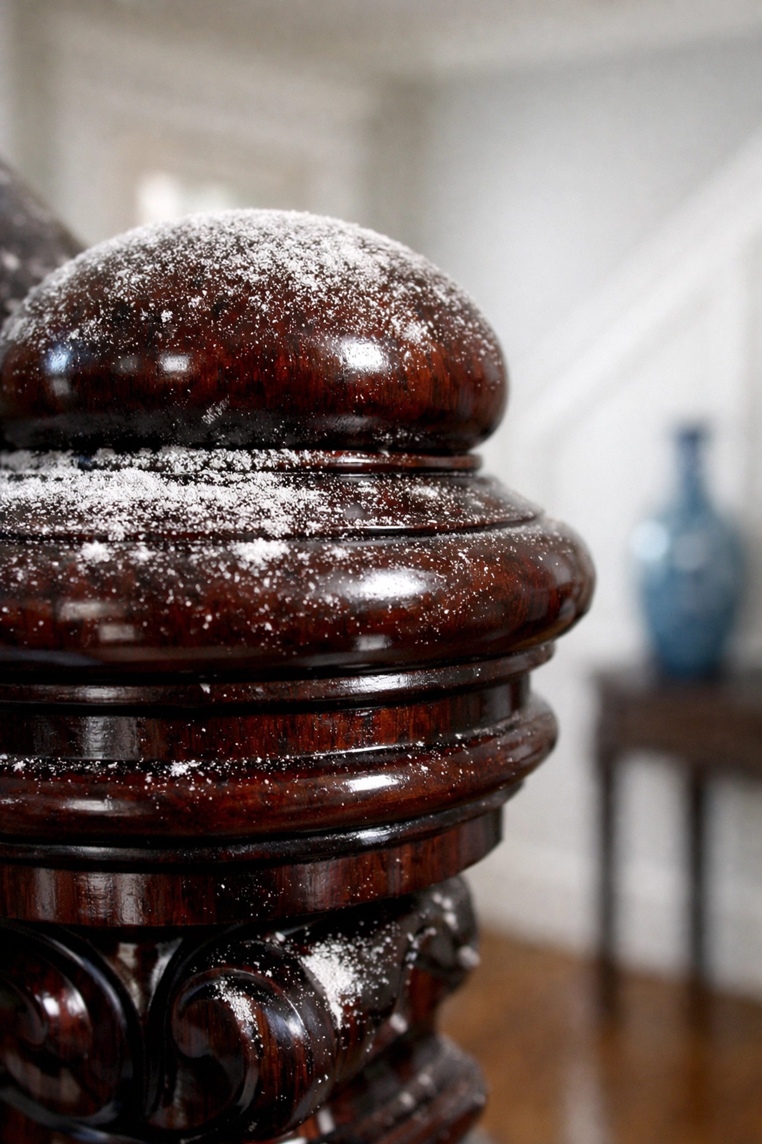 Fine drywall dust on a luxury mahogany banister requiring professional post-construction cleaning MA.