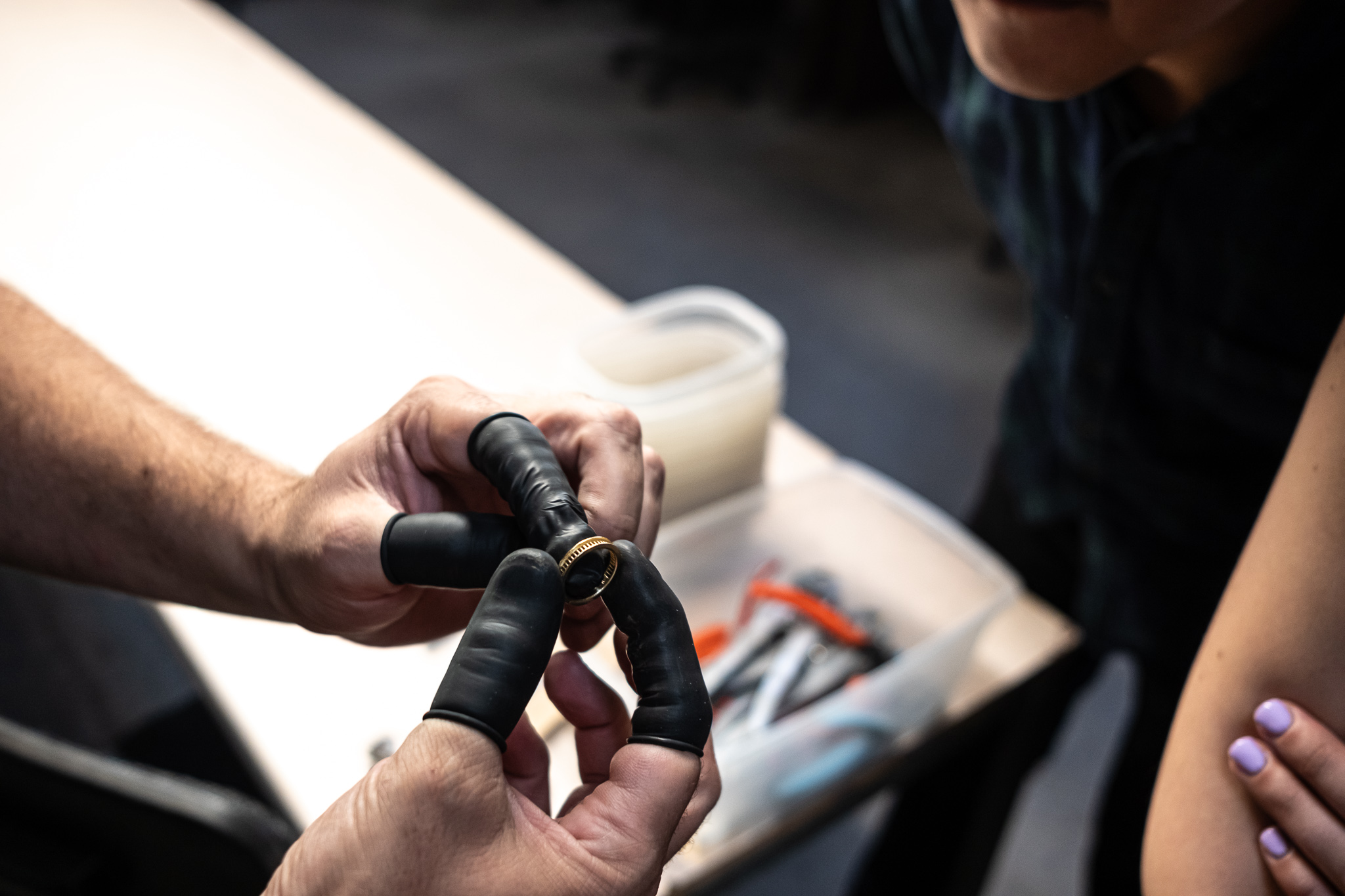 Jewelry artisan inspects gold ring
