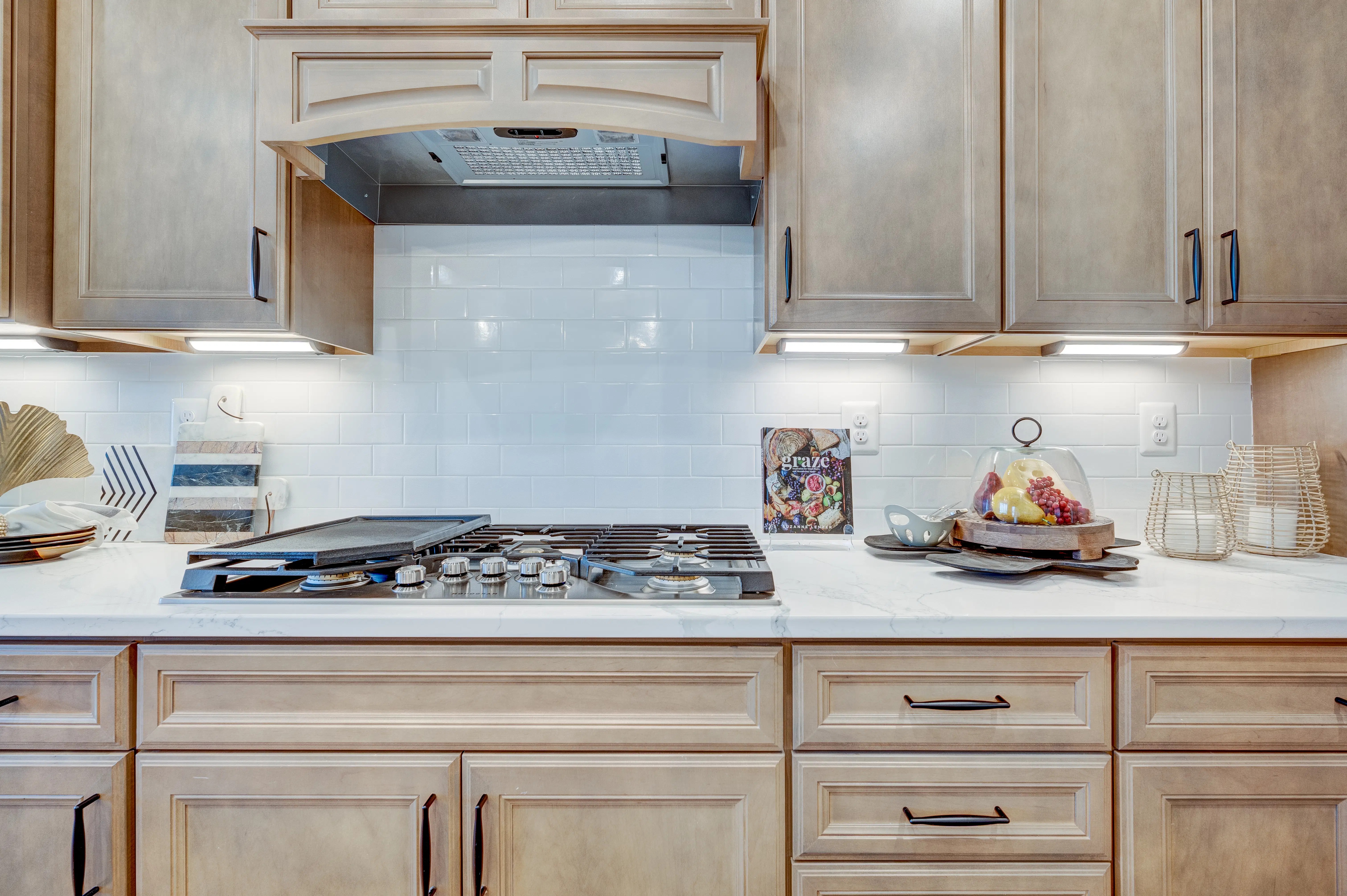 Elegant kitchen countertop with custom wood cabinetry and modern gas cooktop