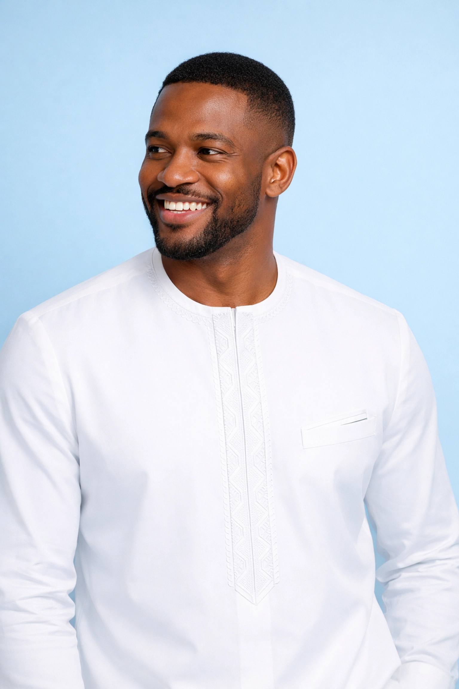 A dapper man in a white Nigerian Senator suit, showcasing the confidence of DerightFS bespoke tailoring.