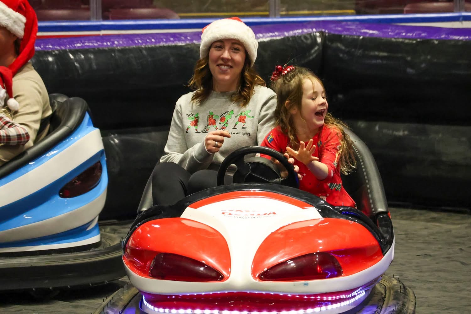A woman and child enjoying a bumper car ride at Party Tyme Amusements