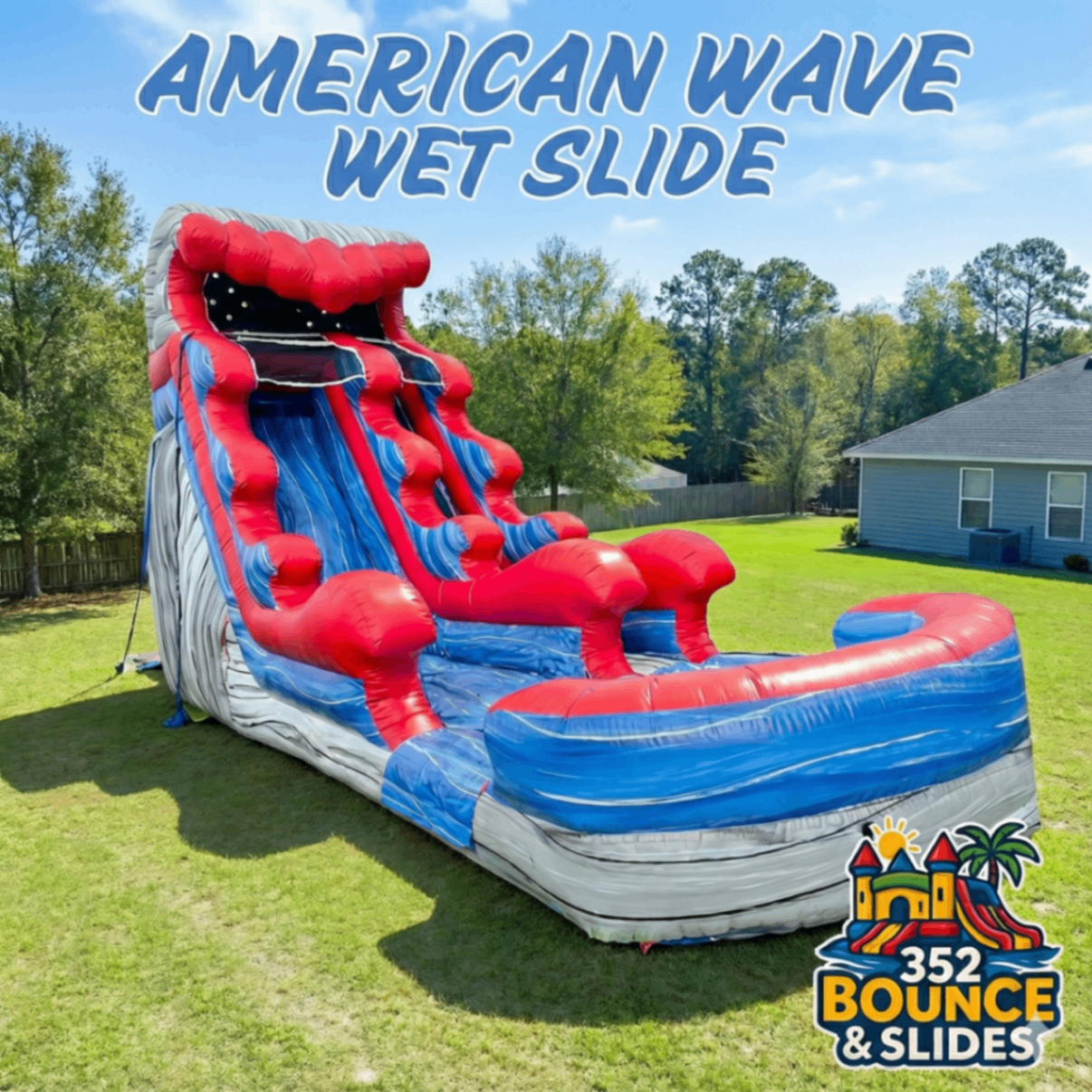 A large inflatable water slide with a red, blue, and gray wave design, set up outdoors on grass.