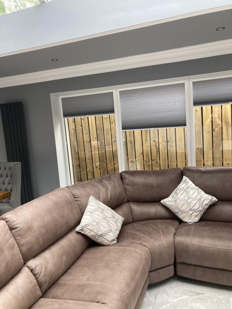 Modern living area featuring Fiesta Blinds’ custom grey cellular blinds