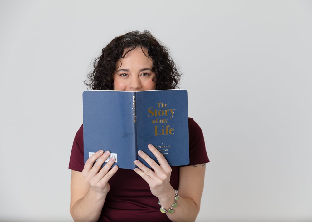 A woman holds a book titled “The Story of My Life” symbolizing Legacy Gurus’ commitment to helping clients preserve their unique life stories.