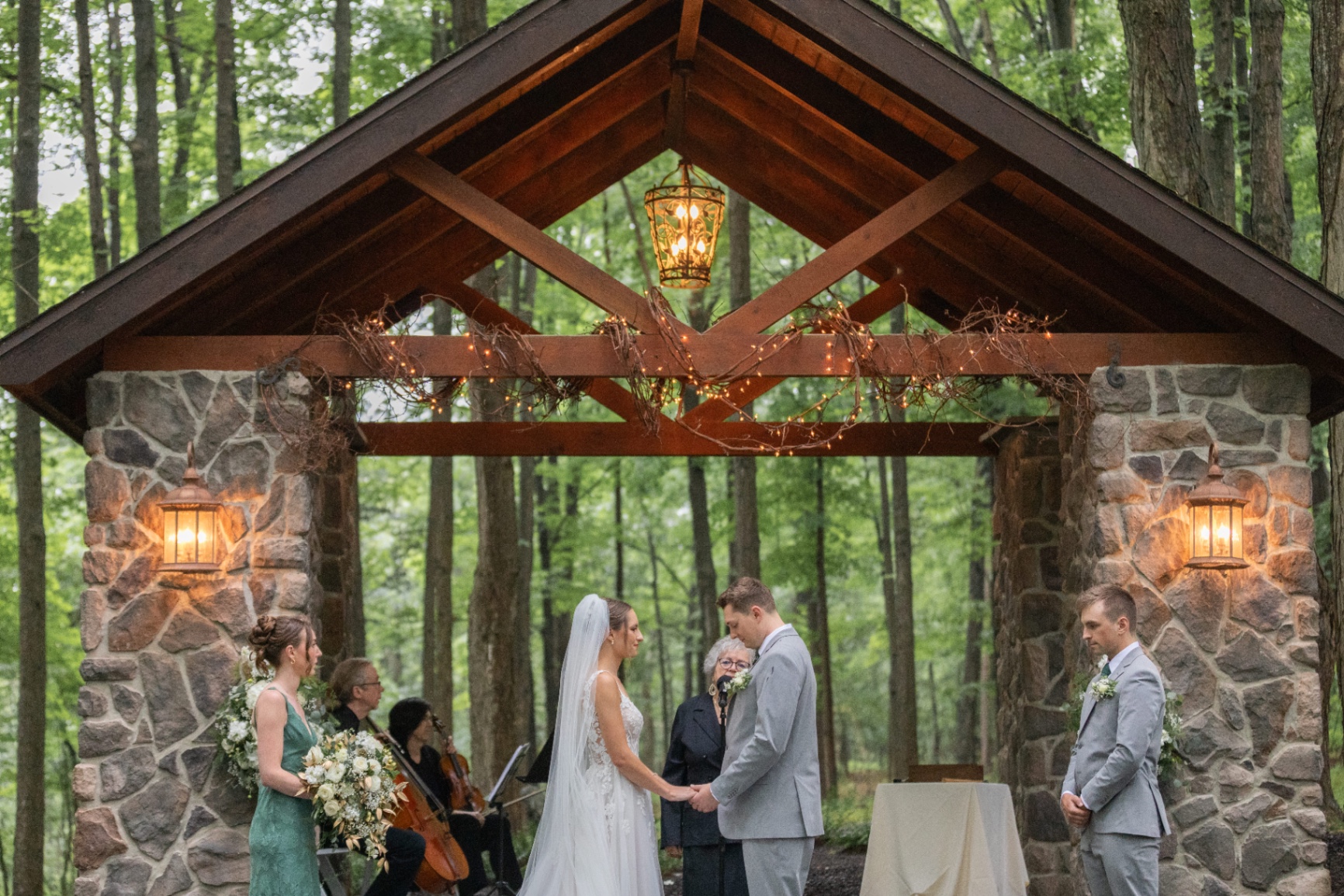 Bride and groom at outdoor ceremony under pavilion