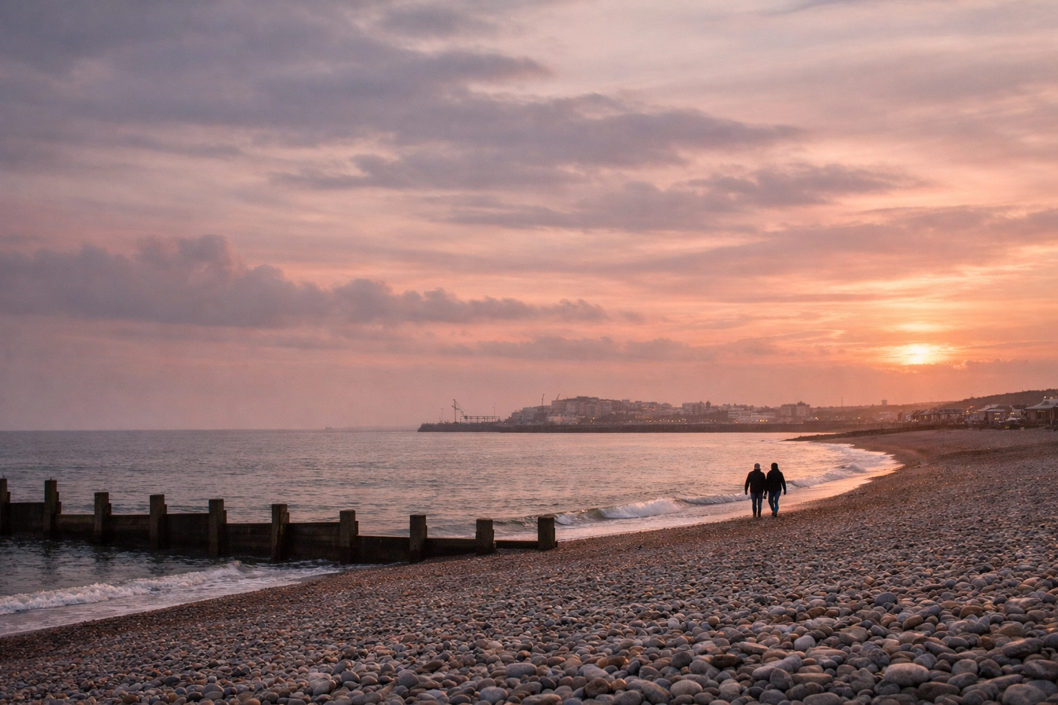 Black Rock Brighton beach at sunset with gay couple walking hand-in-hand toward marina