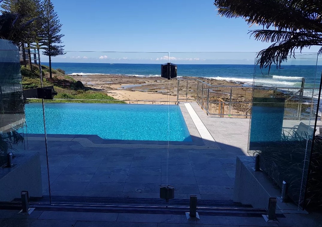 Spotless glass pool fencing and pristine poolside surfaces