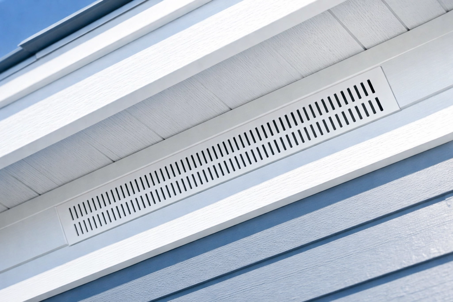 Clean white soffit vent installed under roof eaves for proper attic air intake and ventilation.