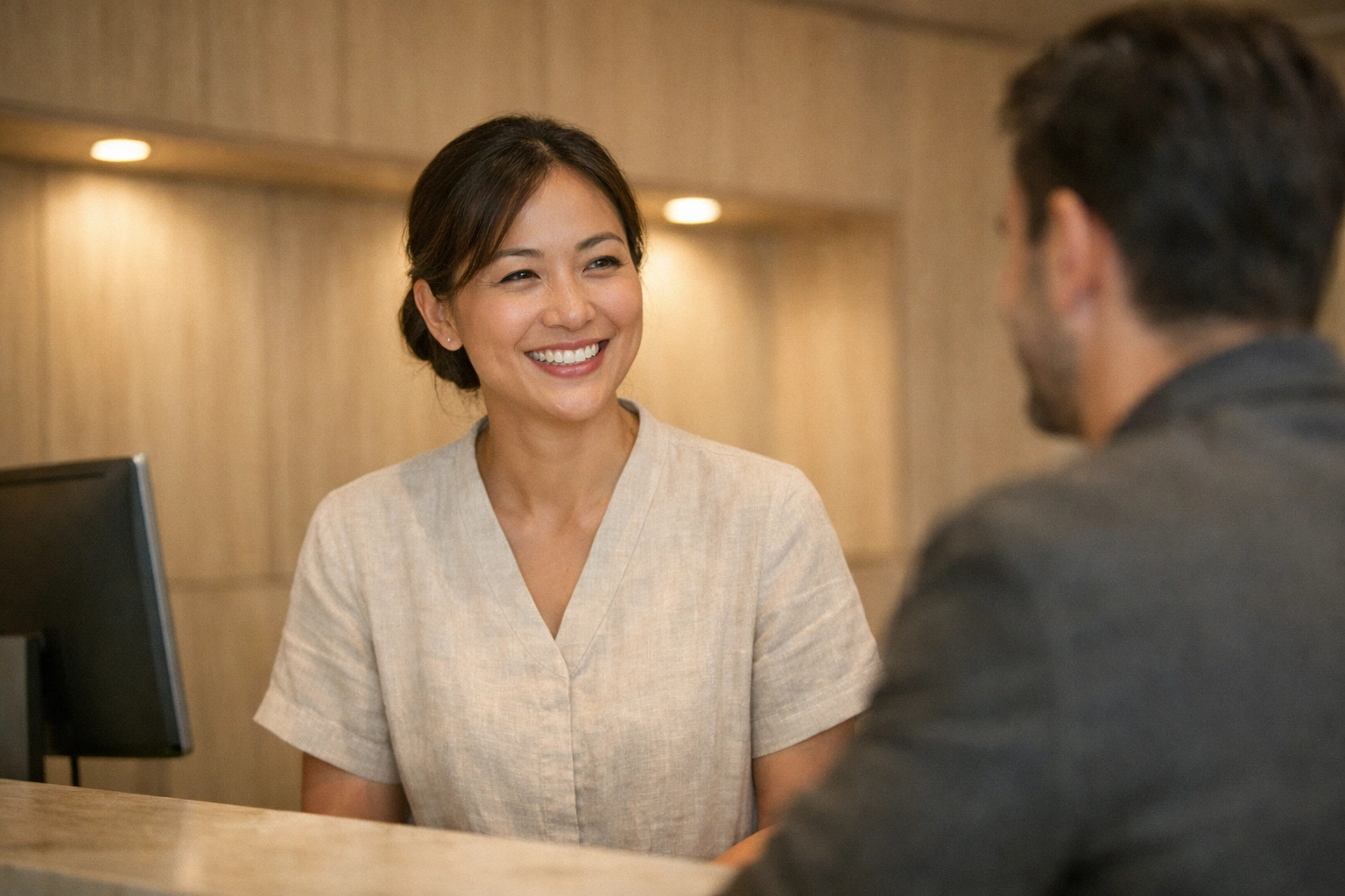 Hotel team engaging with guests in a lobby while an automated hotel pms manages OTA distributions.
