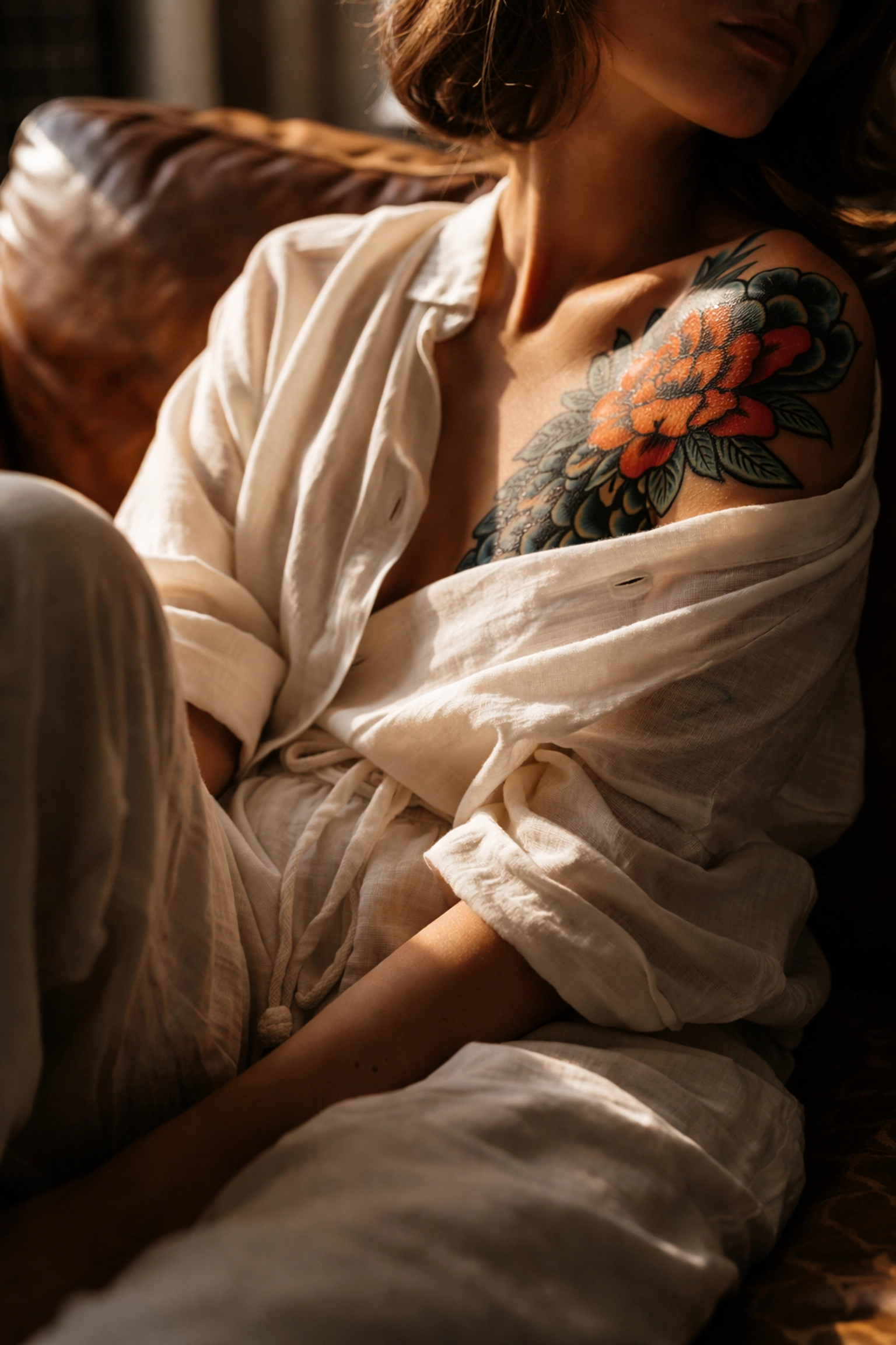 Person wearing loose cotton clothing reveals a brightly colored shoulder tattoo, emphasizing sun protection.