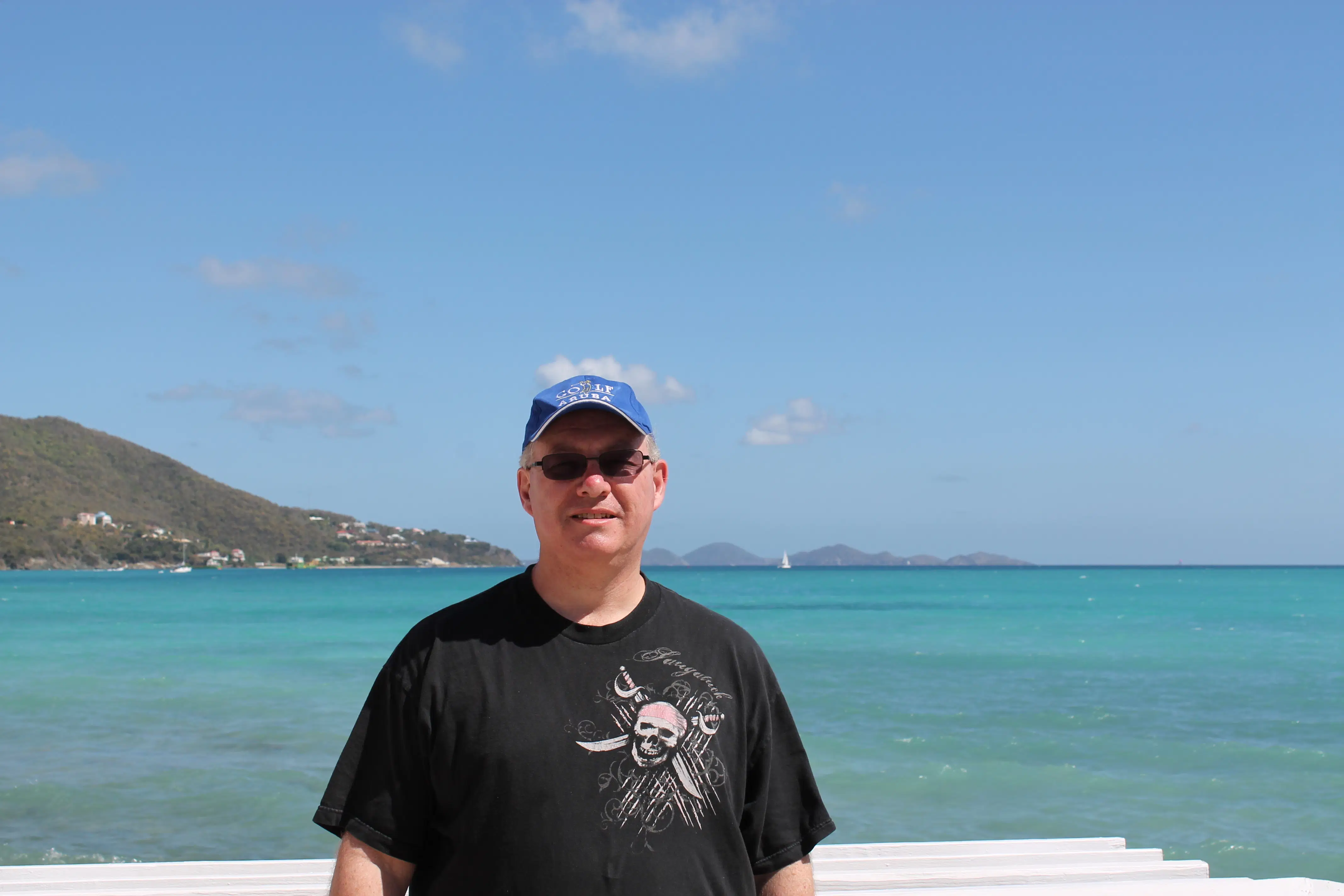 A guest standing in front of turquoise ocean waters, representing the relaxed tropical experience available through our all-inclusive beach resort planning services.