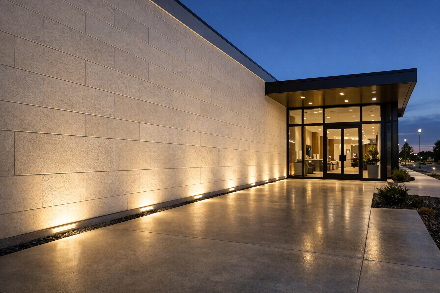 Outdoor wall lighting illuminating a modern commercial entrance and walkway for improved safety and lighting design.