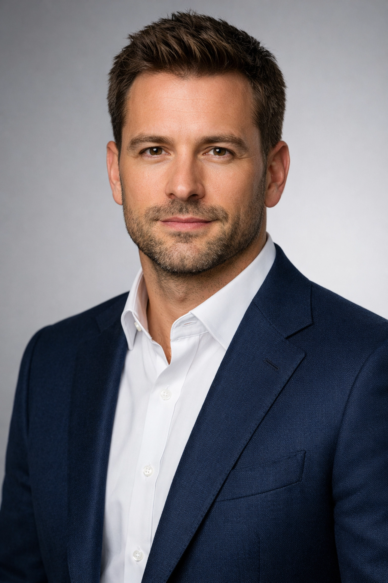 Male executive in a fitted navy blazer, demonstrating professional corporate headshot tips for clothing fit.