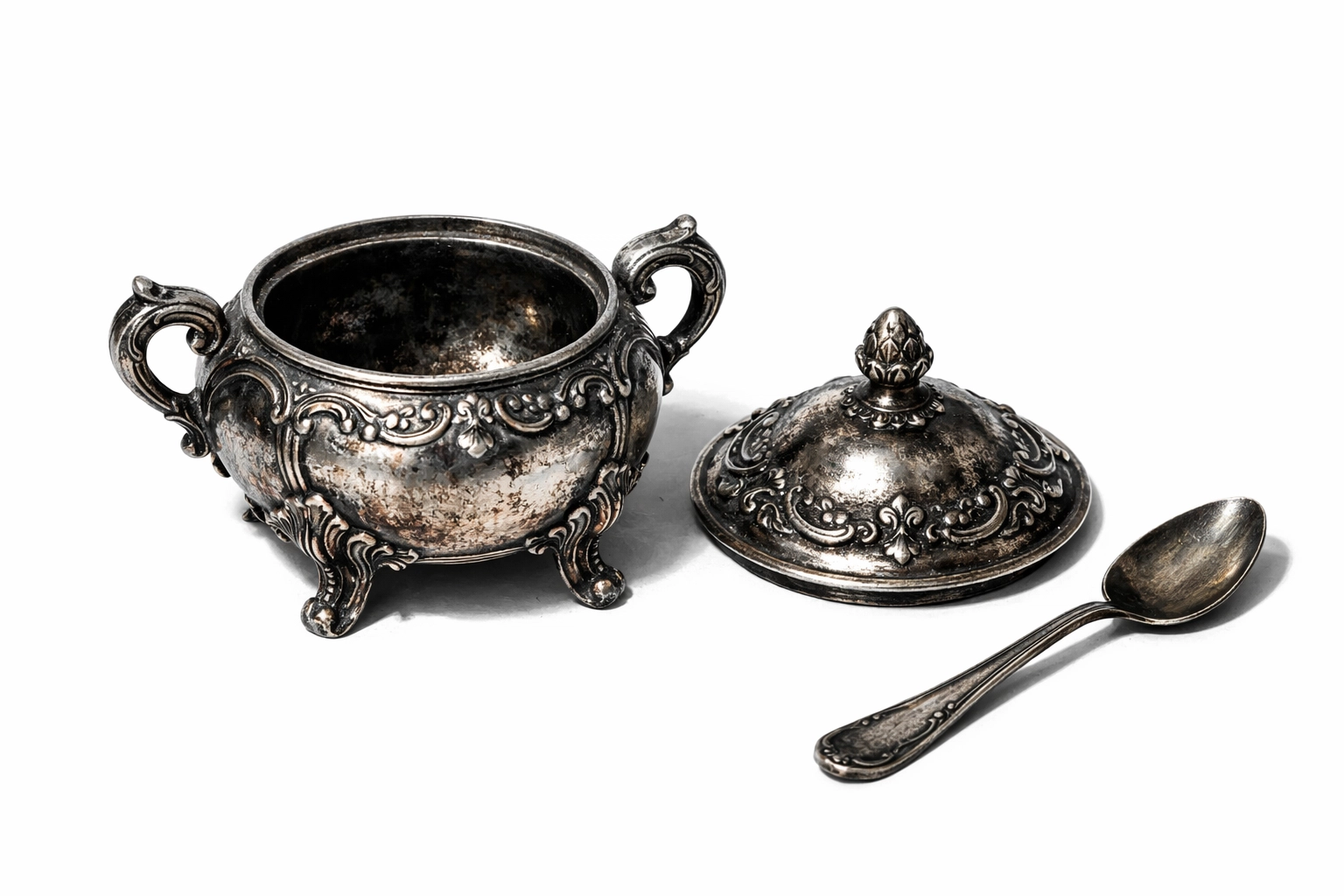Antique silver sugar bowl and spoon on a white background, evoking the mystery of Shirley Jackson's gothic fiction.