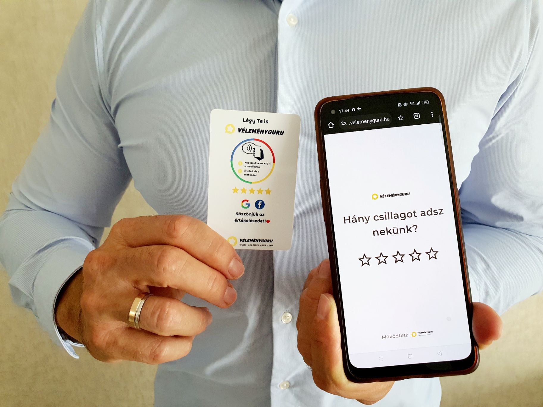 Ügyfél kézben tartja a VéleményGuru NFC kártyát és egy okostelefont