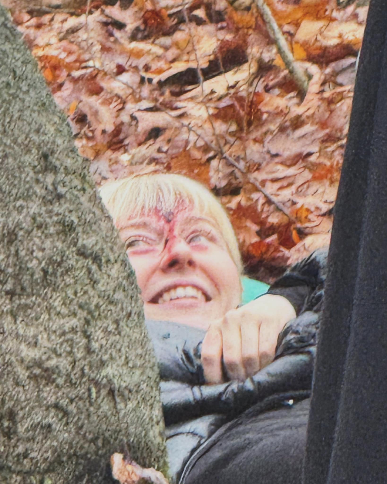 A close-up production still showing an actor in a dramatic forest scene