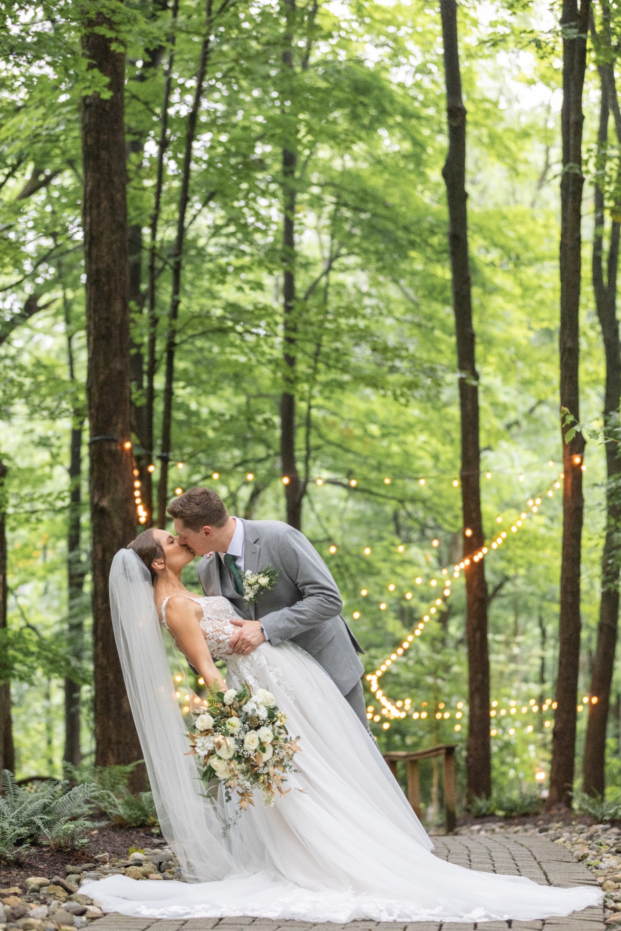 Bride and groom sharing a kiss in wooded setting