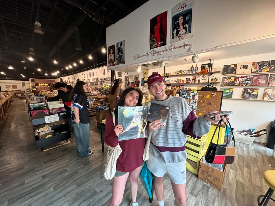Two happy customers holding their vinyl finds at Nivessa
