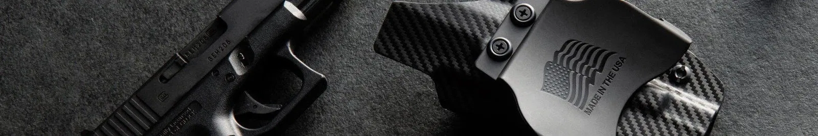 A close-up of a black handgun and a carbon fiber-patterned KYDEX holster
