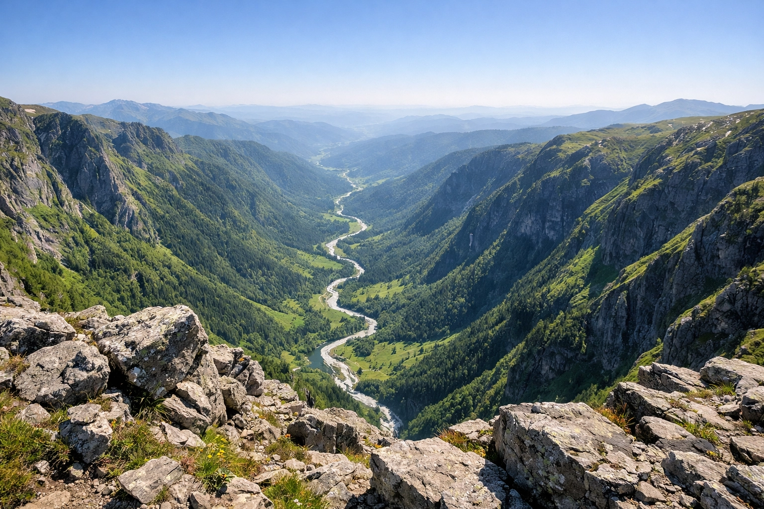 Aerial view from a mountain summit overlooking a green valley and stream in the Lake District this spring.