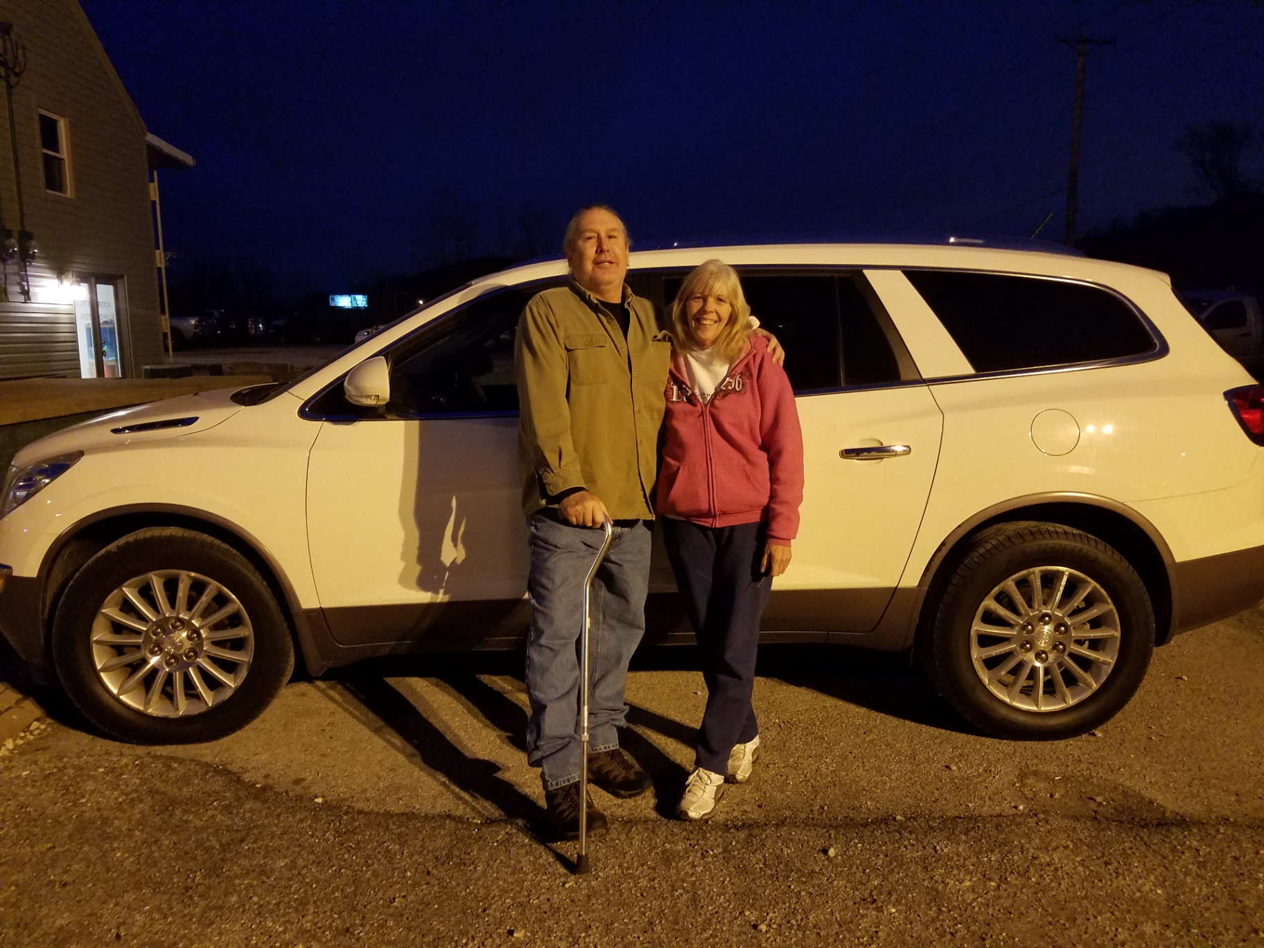 Smiling Couple with New White SUV at Grateful Motors