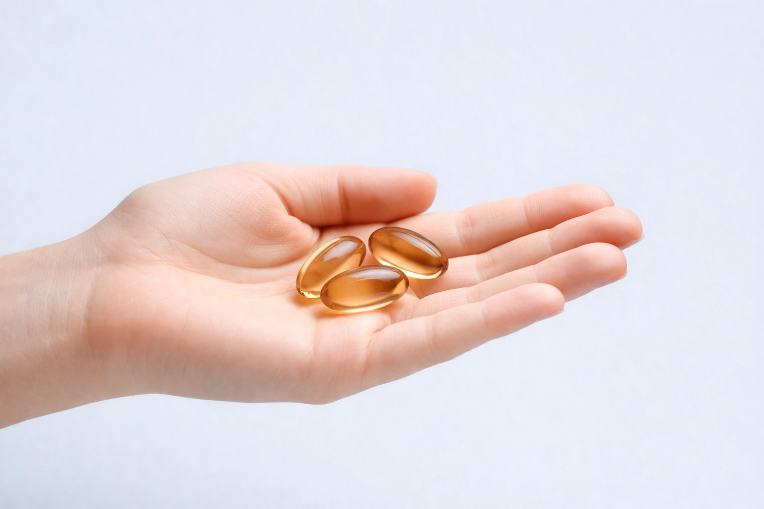 Hand holding three Apricot Kernel Capsules 2500mg, emphasizing supplement dosage and safety.