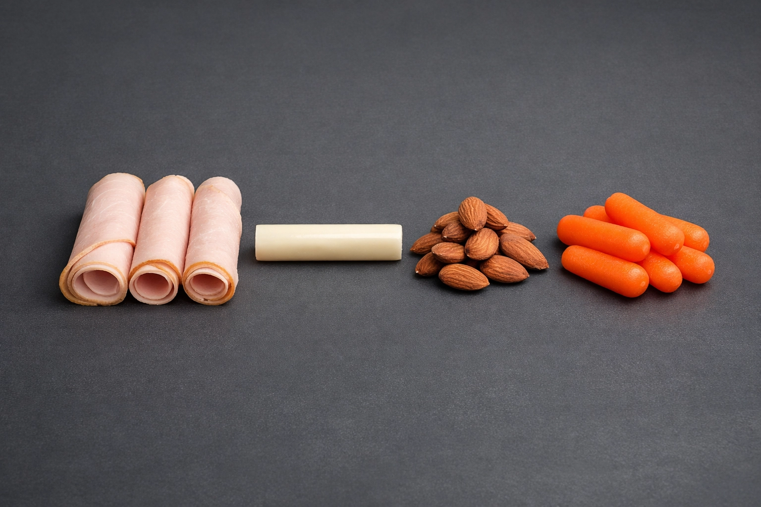 Healthy snack plate with turkey rolls, cheese, and almonds, ideal for high-protein office grazing.